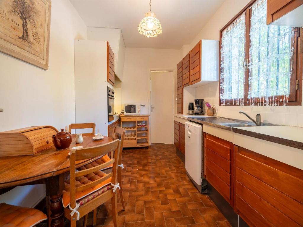 Il comprend une cuisine avec une table en bois et du parquet. dans l'établissement Villa in France with Vineyards and Nature Views, cleaning included, à Puisserguier