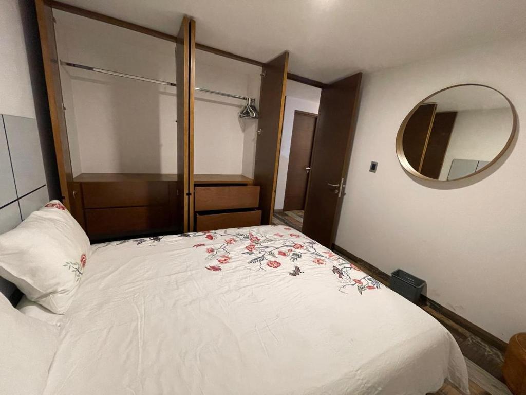 モレリアにあるDepartamento Chapultepecのベッドルーム1室(花が咲く白いベッド1台付)