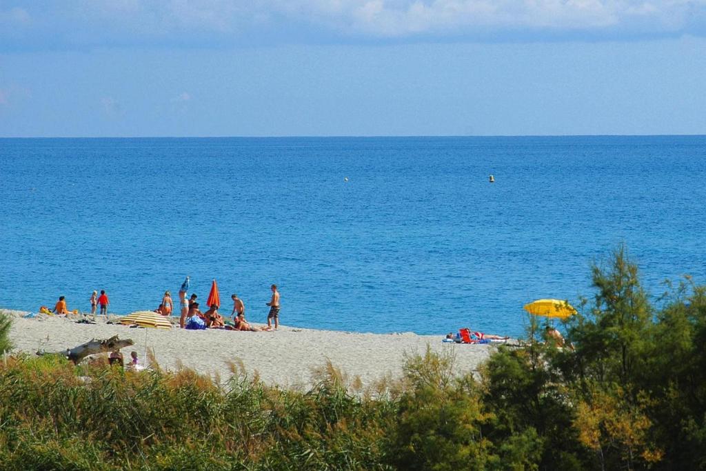 un groupe de personnes sur une plage avec l'océan dans l'établissement Apartment in Ghisonaccia near Sandy Beach, cleaning included, à Ghisonaccia