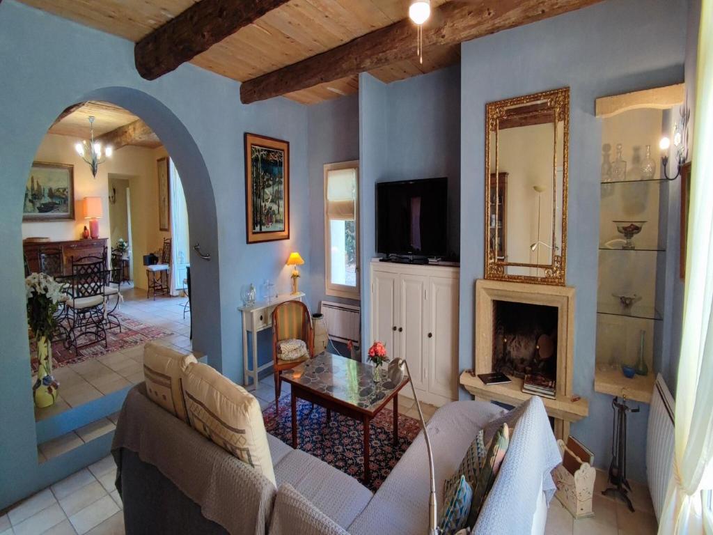 un salon avec un canapé et une cheminée dans l'établissement Villa in France with Pool and Vineyards, cleaning included, à Puisserguier