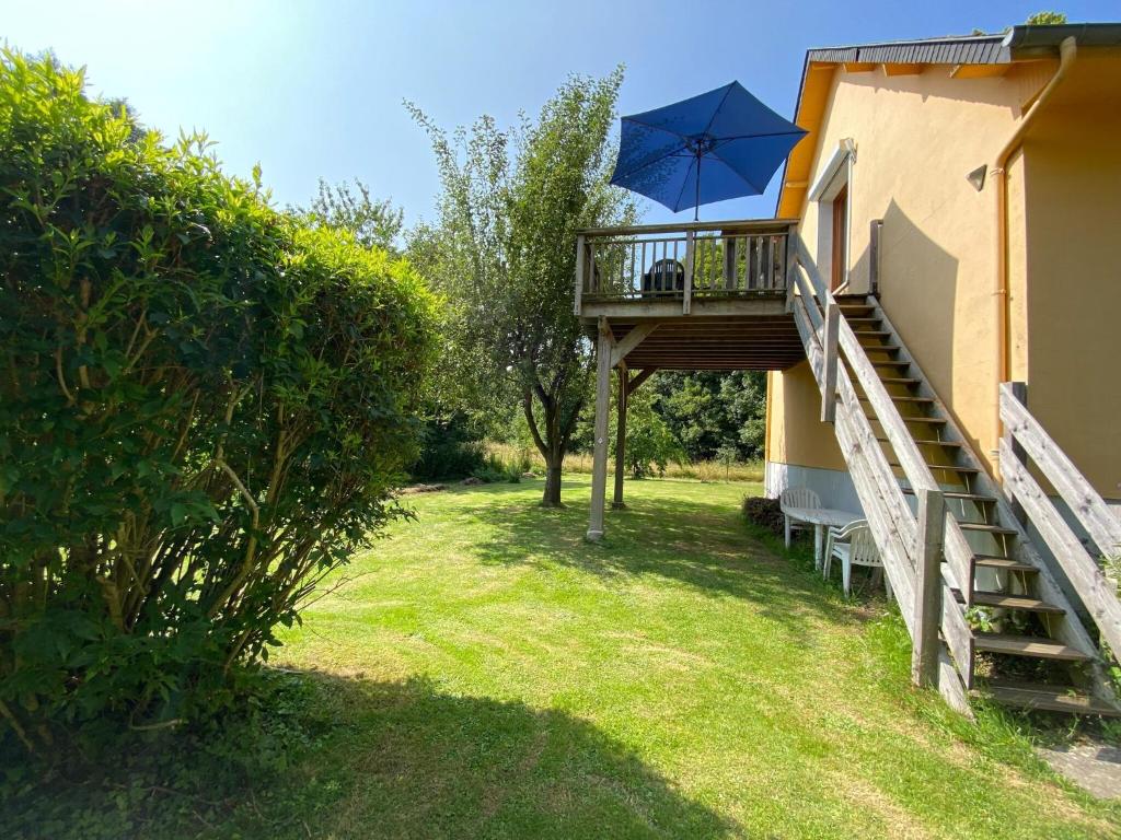 un balcon avec un parasol bleu à côté d'un immeuble dans l'établissement Apartment near Alabaster Coast beaches, cleaning included, à Manneville-ès-Plains