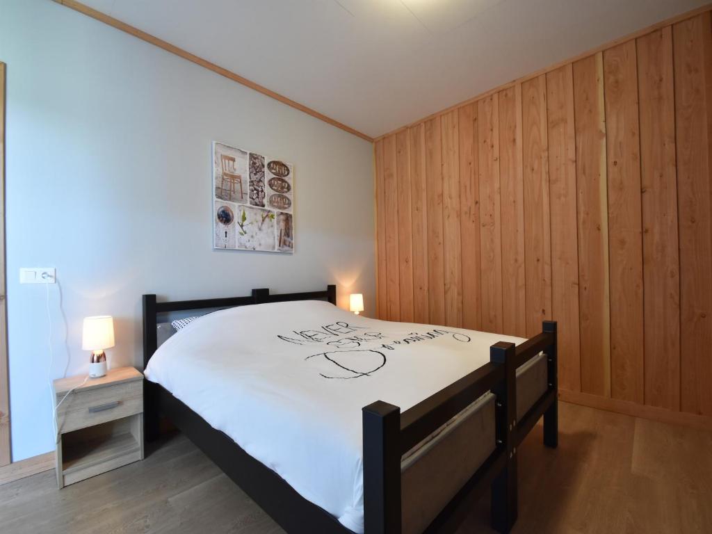 une chambre avec un grand lit dans une pièce aux murs en bois dans l'établissement Mansion in Cuzy with Pool & Forest Views, cleaning included, à Cuzy