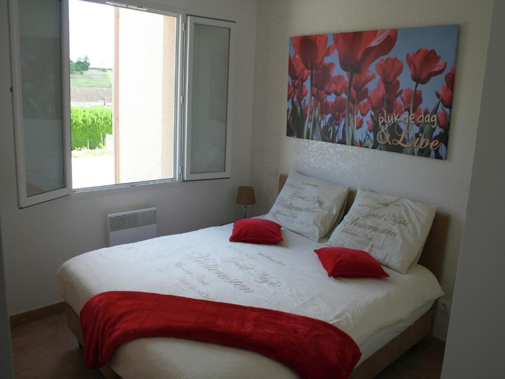 une chambre avec un lit avec deux oreillers rouges dans l'établissement Poolside Apartment in Segonzac, cleaning included, à Segonzac