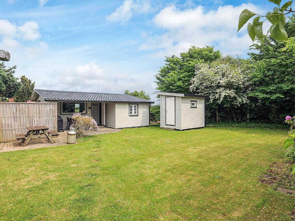 a backyard with a shed and a picnic table at 6 person holiday home in Løkken in Løkken