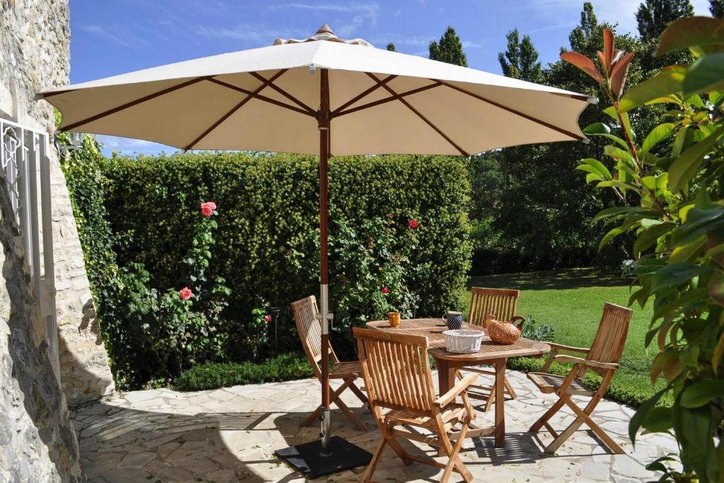 - une table et des chaises sous un parasol sur la terrasse dans l'établissement Charming Stone House with Terrace, cleaning included, à Lussan