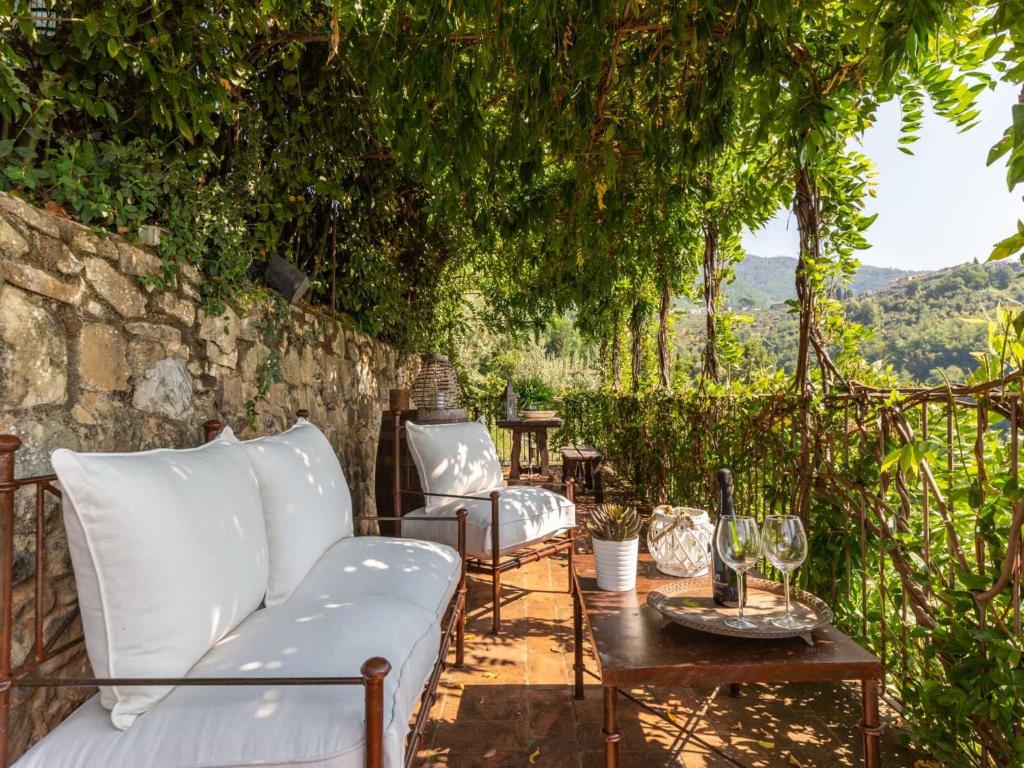 a patio with a couch and chairs under a tree at Tuscan Farmhouse with Infinity Pool Retreat in Matraia
