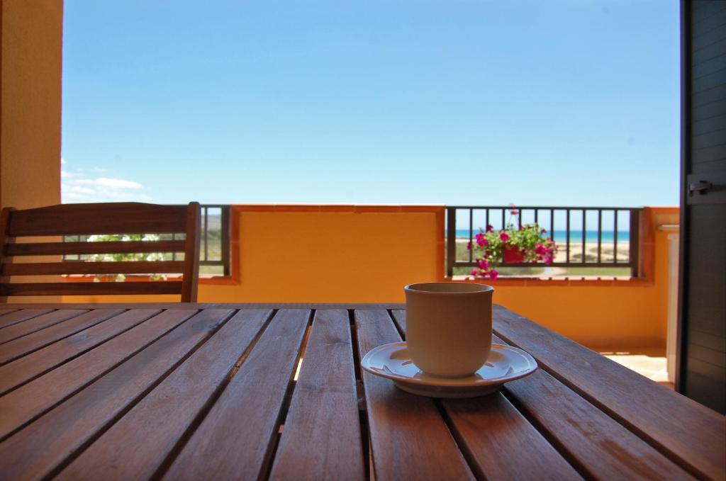 una tazza di caffè seduta su un tavolo di legno sul balcone di Le Terrazze - "dalla Nonna" a Siculiana Marina