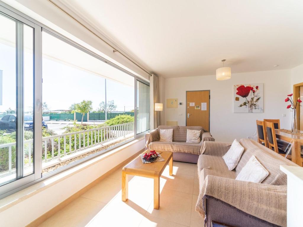 een woonkamer met banken en een groot raam bij An Idyllic Algarve Home by the Water, cleaning included in Fuzeta