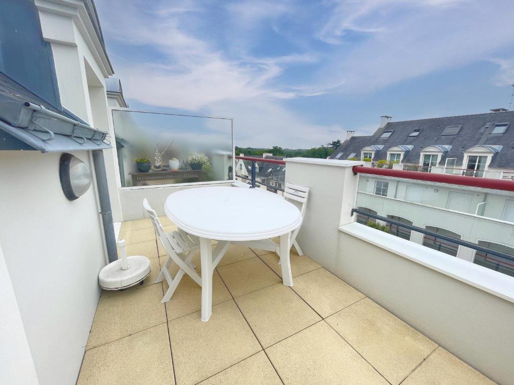 un petit balcon avec une table blanche et des chaises dessus dans l'établissement Spacieux appartement pour 6 pers. avec balcon, Sarzeau - FR-1-639-147, à Sarzeau