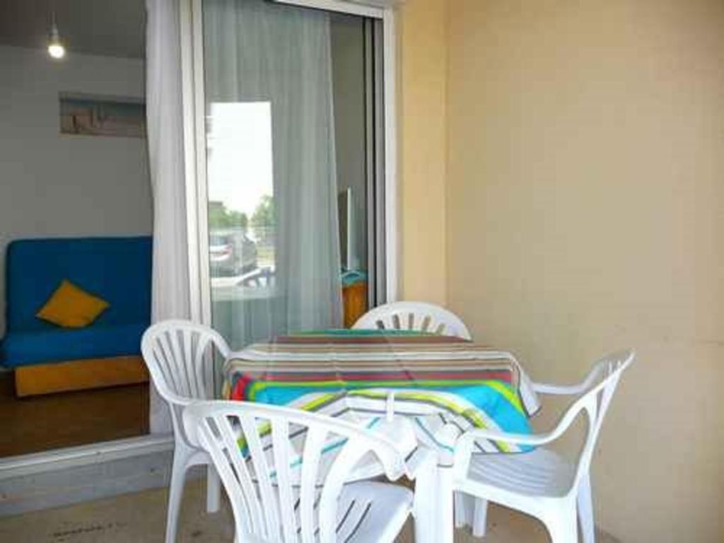 - une table et des chaises avec une couverture colorée dans l'établissement Appartement 2 pièces, accès plage, parking privé, Le Barcarès - FR-1-782-79, au Barcarès