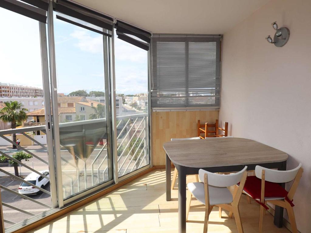 une salle à manger avec une table et un balcon dans l'établissement 2 pièces avec loggia, piscine à 200m de la plage - FR-1-307-289, au Grau-du-Roi