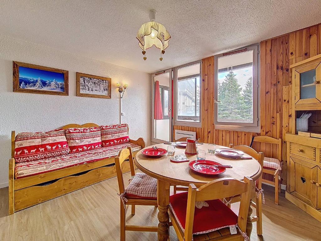 une salle à manger avec une table et un lit dans l'établissement Studio au pied des pistes avec balcon sud - FR-1-344-1229, aux Menuires