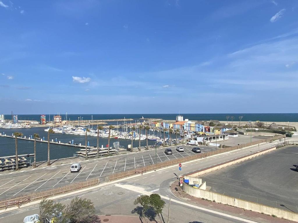 une vue d'une route avec une marina et des voitures dans l'établissement Studio vacances Le Barcarès, vue port, terrasse, parking - FR-1-782-81, au Barcarès