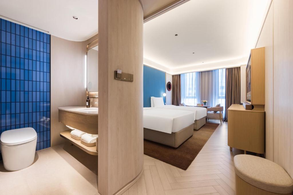 Postel nebo postele na pokoji v ubytování Tianjin Baodi Economic Development Zone Orange Crystal Hotel
