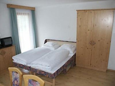 a bed in a room with two chairs and a window at Appartements Mattioli in Samnaun