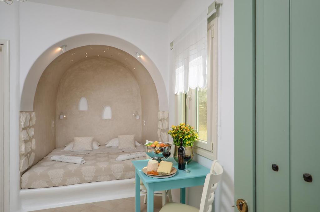 um quarto com uma cama e uma mesa azul em Naxos Euphoria Suites em Stelida