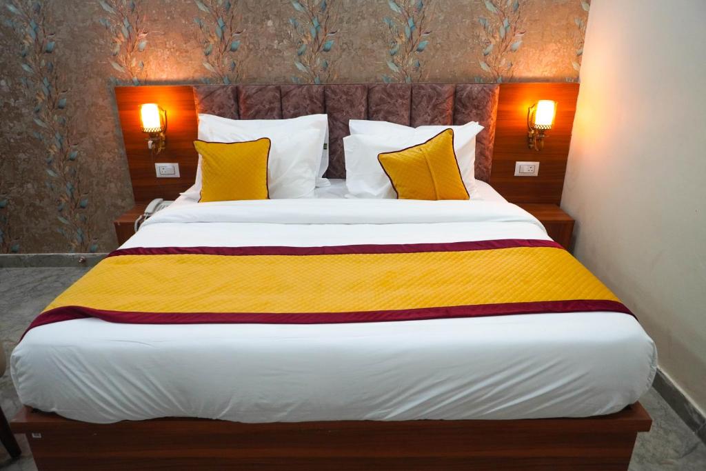 a bedroom with a large bed with yellow and white pillows at Hotel Relax Suites FNG Expresway 63 Noida in Noida