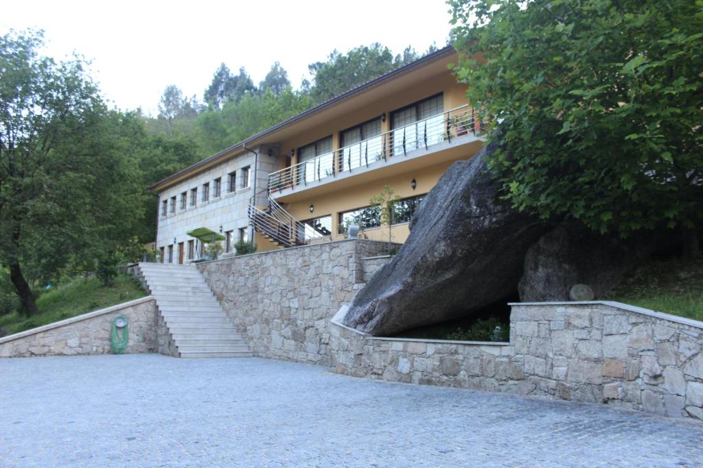 ein Gebäude mit einer großen Steinmauer und einer Treppe davor in der Unterkunft Pála dos Mouros in Geres
