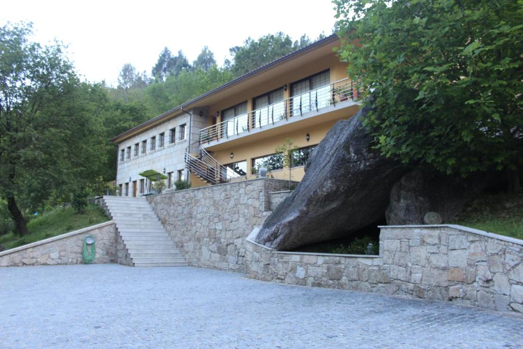 un edificio con una gran pared de piedra y escaleras delante en Pála dos Mouros en Geres