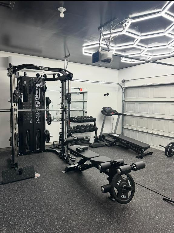 a fitness room with a gym with a treadmill and weights at Green Meadow Homestay in San Antonio