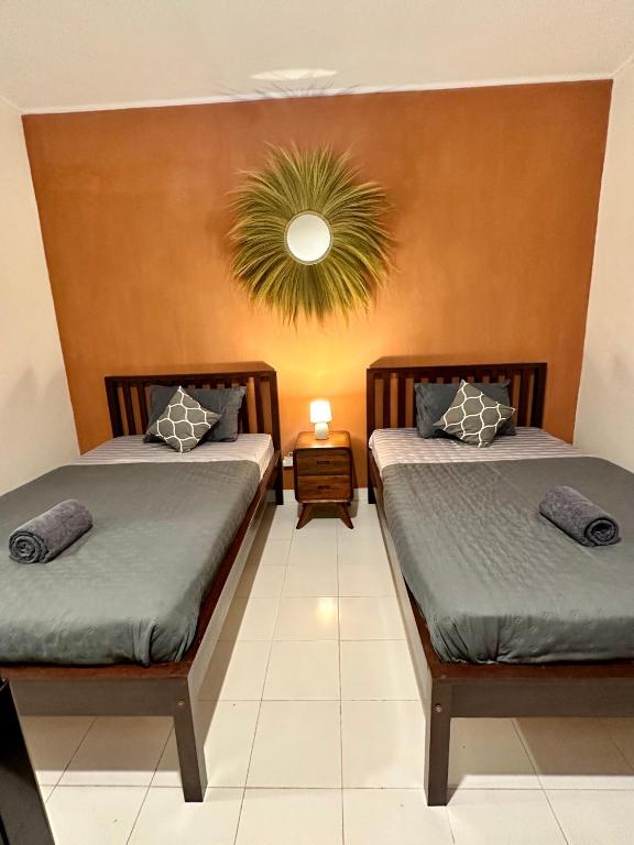a bedroom with two beds and a potted plant at Simon Homestay in Sanur