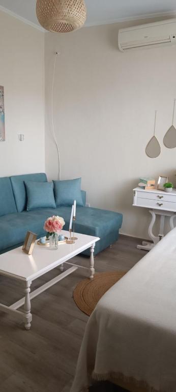 a living room with a blue couch and a coffee table at Dream house Peramos in Nea Peramos