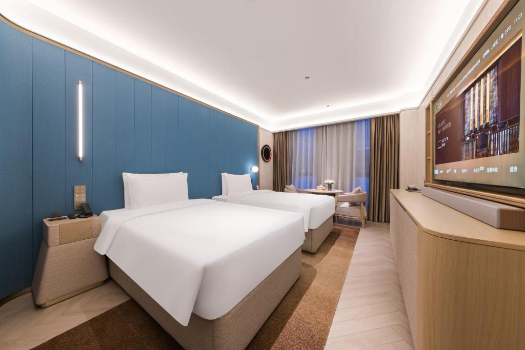 Postel nebo postele na pokoji v ubytování Tianjin Baodi Economic Development Zone Orange Crystal Hotel