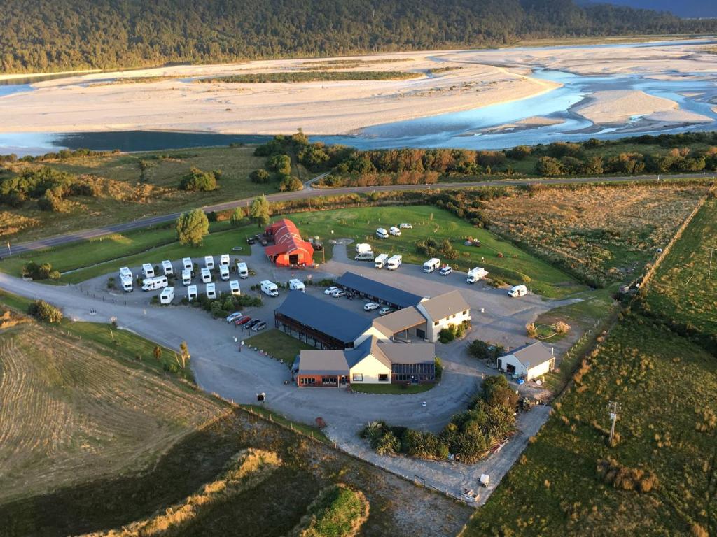 an aerial view of a parking lot next to a beach at Haast River Motels & Holiday Park in Haast