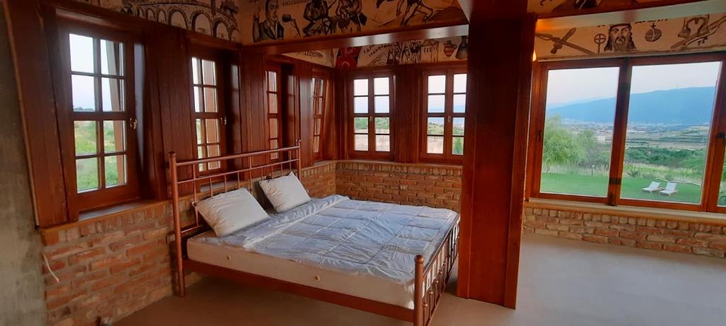 een slaapkamer met een bed in een kamer met ramen bij Macedonium Luxury Villa with big pool & Fireplace in Skopje