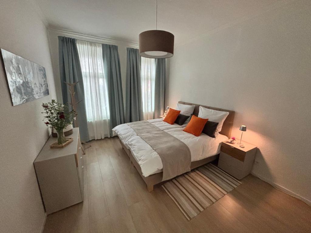 een slaapkamer met een bed en 2 tafels met lampen bij FeWo Sonnenberg in Chemnitz