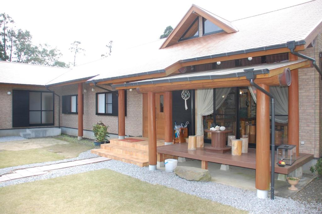een huis met een veranda met een bankje ervoor bij Yakushima Pension Ichigoichie in Yakushima
