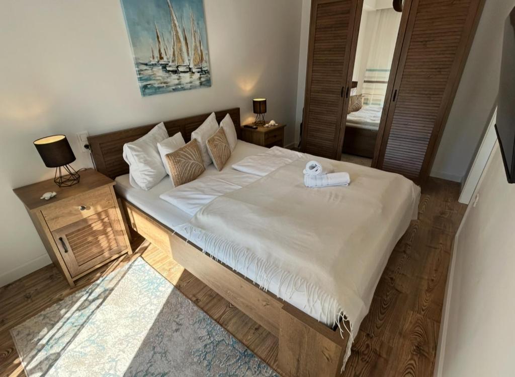 a bedroom with a large bed with white sheets at Elina Apartman in Keszthely