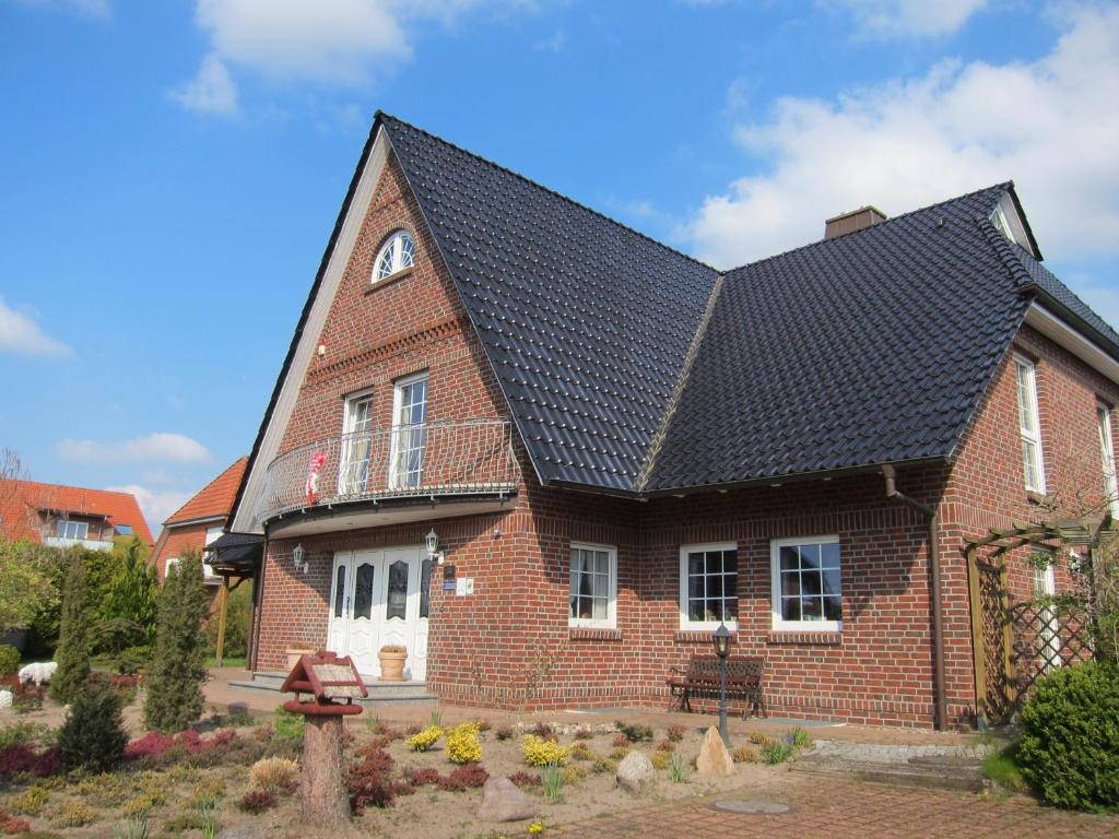 a red brick house with a black roof at Hotel Heidetraum in Schneverdingen
