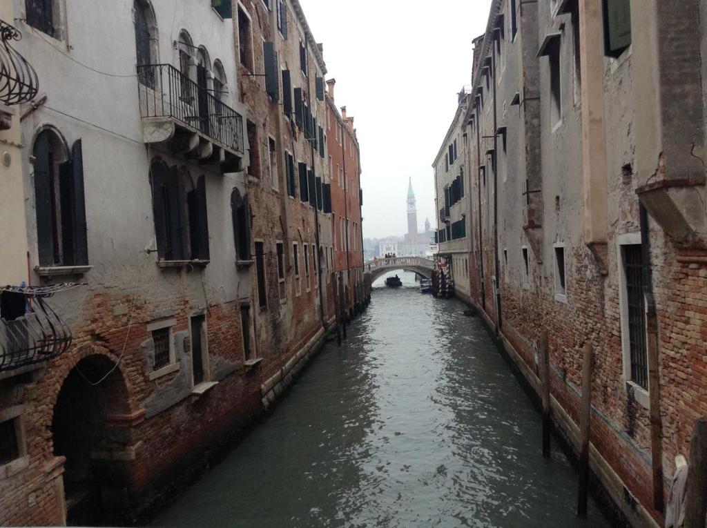 a canal between two buildings with a bridge in the background at Ca dei Libri in Venice