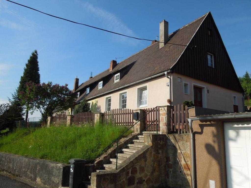 une maison blanche avec un toit noir dans l'établissement Apartments Benešov Nad Ploučnicí, à Benešov nad Ploučnicí