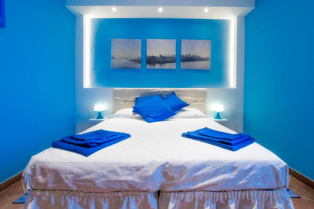a blue bedroom with a white bed with blue pillows at Hotel Rainbow in Arma di Taggia