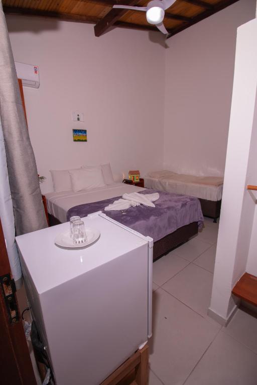 a room with two beds and a sink in it at Pousada do Mineiro in Trancoso