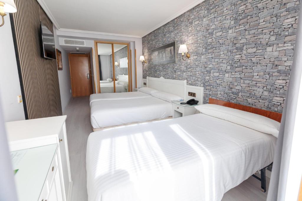 Postel nebo postele na pokoji v ubytování Hotel Ciudad Cangas de Onis