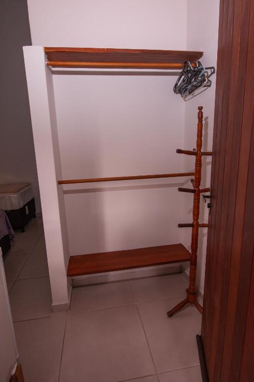 a closet with a wooden bench in a room at Pousada do Mineiro in Trancoso