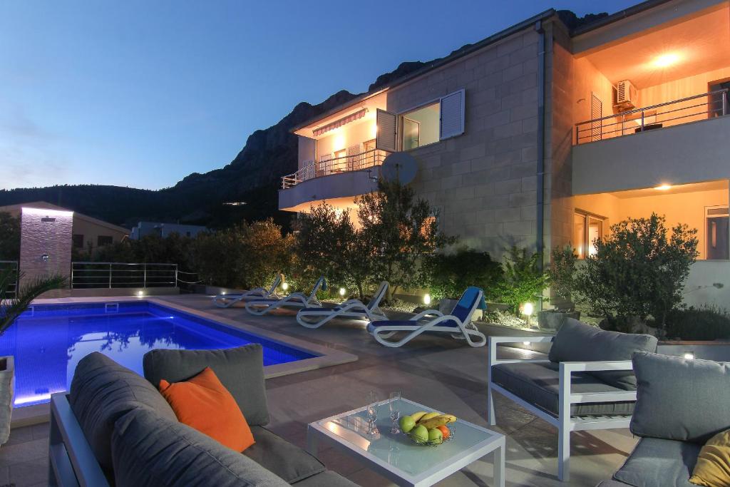 a backyard with a swimming pool and a house at Villa Levanda in Makarska