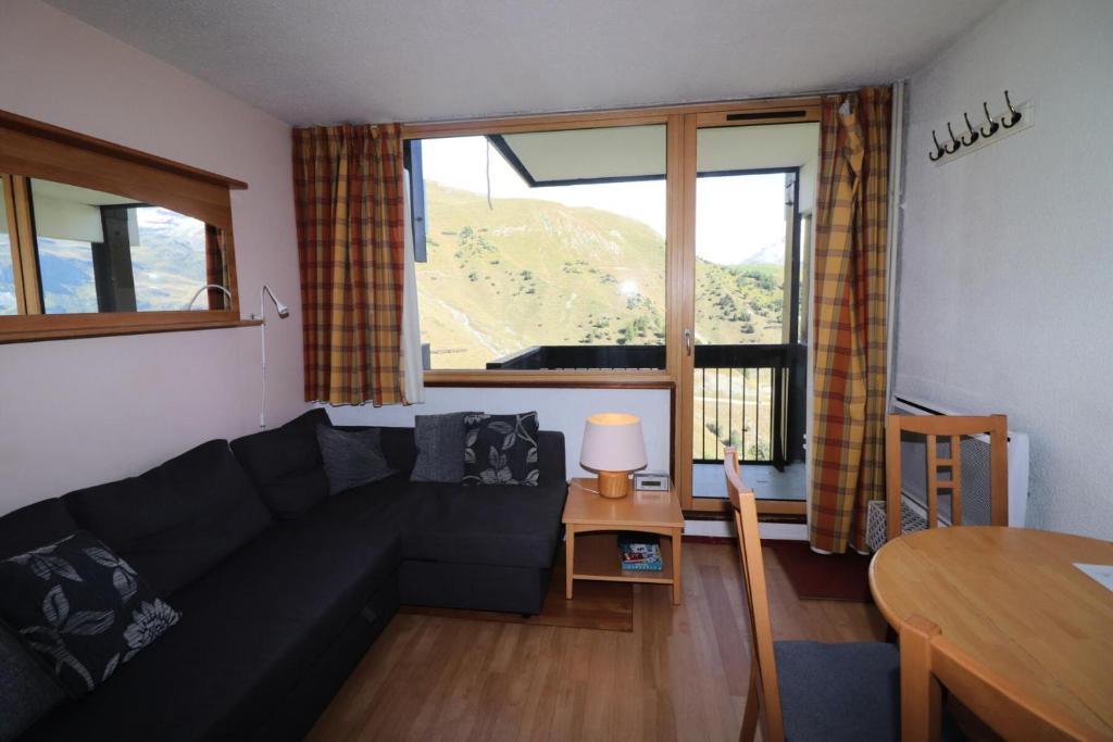 un salon avec un canapé noir et une table dans l'établissement Résidence Home Club - Studio avec vue imprenable retour ski aux pieds MAE-3904, à Tignes