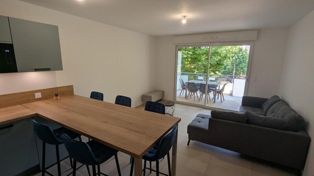 un salon avec une table et un canapé dans l'établissement appartement neuf en centre-ville, à Cavalaire-sur-Mer