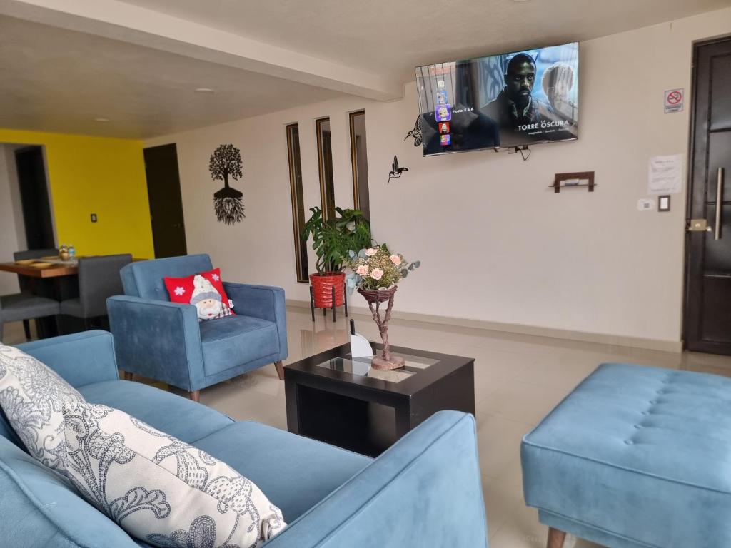 a living room with two blue couches and a table at Hostal K & A in Zacatlán