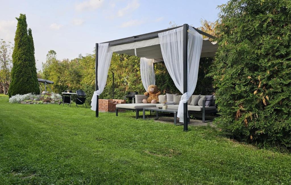 a teddy bear sitting on a couch under a canopy at Verebes Cottage with garden in Tuşnad