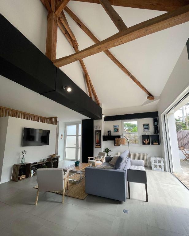 un salon avec un canapé et une table dans l'établissement Villa Cinta, des vacances en bord d'océan, à Capbreton