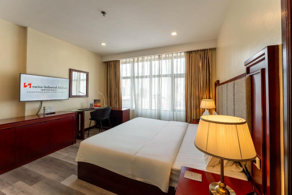 Postel nebo postele na pokoji v ubytování Swiss-Belhotel Blulane