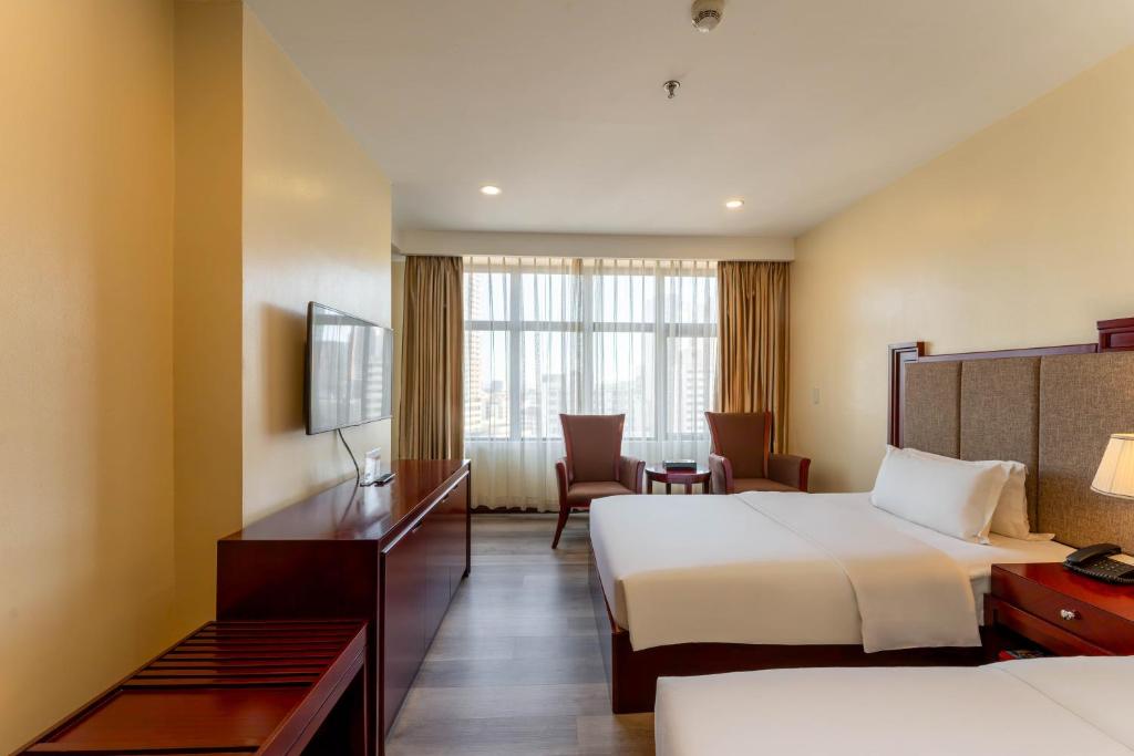 Postel nebo postele na pokoji v ubytování Swiss-Belhotel Blulane