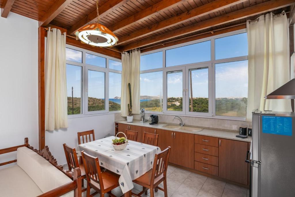 a kitchen with a table and some windows at Kondylis Cottage in Provatas