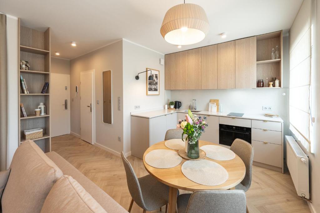 a kitchen and dining room with a table and chairs at Apartament Wejhera II in Puck