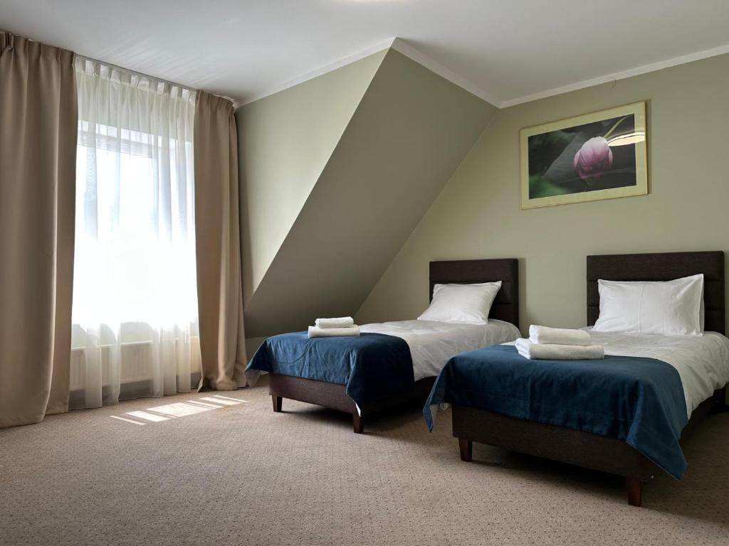 a bedroom with two beds and a window at Villa FOREST in Poznań